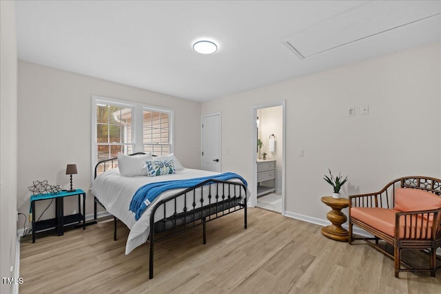 bedroom featuring ensuite bath, light wood-style flooring, and baseboards