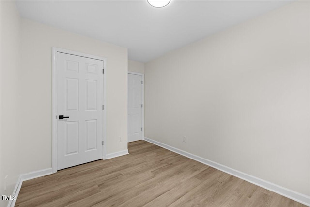 unfurnished bedroom with light wood finished floors and baseboards