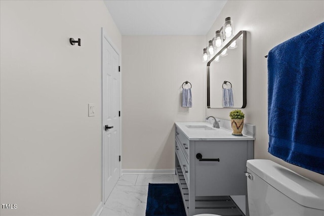 bathroom featuring marble finish floor, vanity, toilet, and baseboards