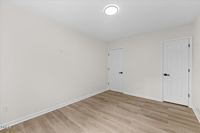 spare room with light wood-style flooring and baseboards