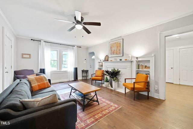 1209 Eva St, Durham, NC 27703 - living room featuring ornamental molding, arched walkways, a ceiling fan, wood finished floors, and baseboards