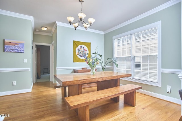 dining area featuring ornamental molding, baseboards, light wood-type flooring, and a notable chandelier