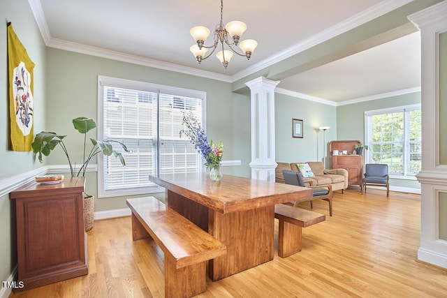 dining room with light wood-type flooring, decorative columns, and ornamental molding