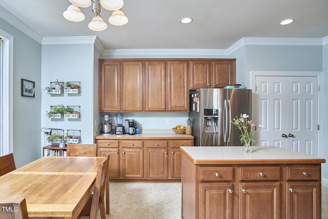 kitchen featuring brown cabinetry, a notable chandelier, crown molding, and stainless steel fridge