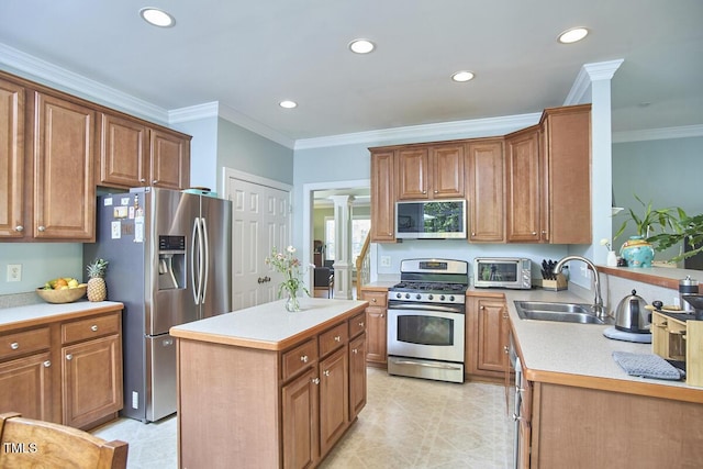 kitchen with decorative columns, ornamental molding, recessed lighting, appliances with stainless steel finishes, and a sink