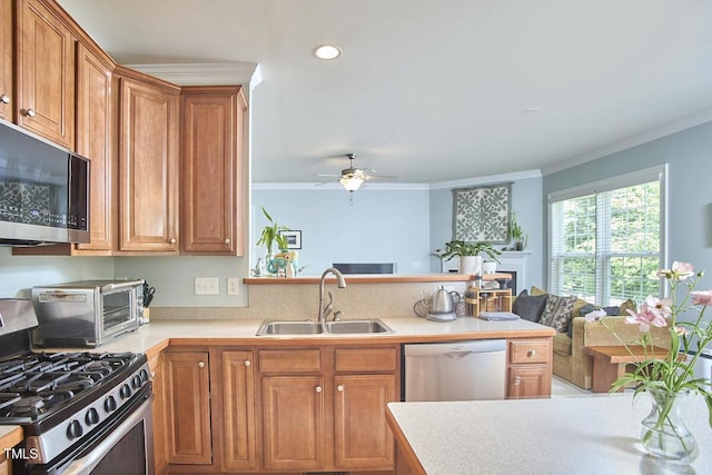 kitchen with stainless steel appliances, a peninsula, a sink, and ornamental molding