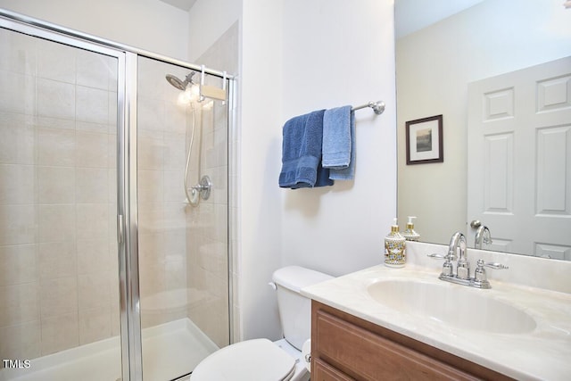 bathroom featuring a shower stall, vanity, and toilet