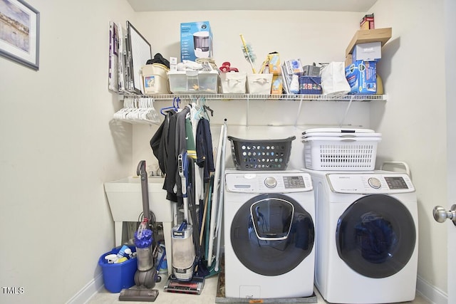 washroom featuring washing machine and dryer, laundry area, and baseboards