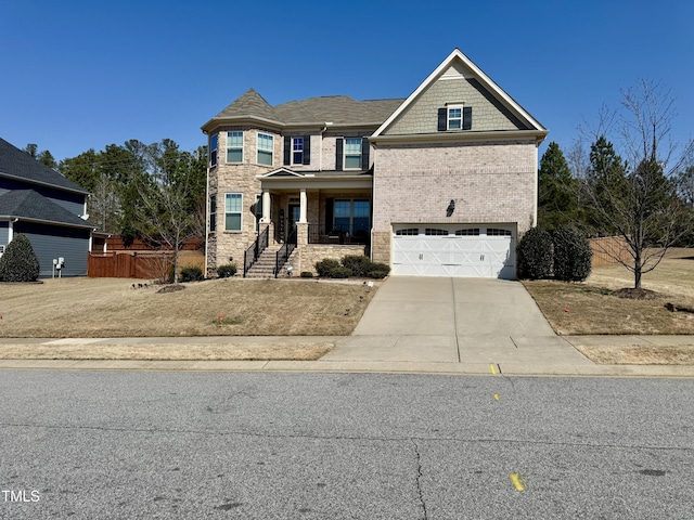 view of front of home with an attached garage, brick siding, fence, driveway, and stone siding