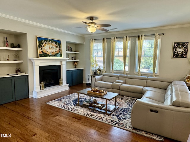 living area with dark wood-style floors, a fireplace with raised hearth, ornamental molding, and a wealth of natural light