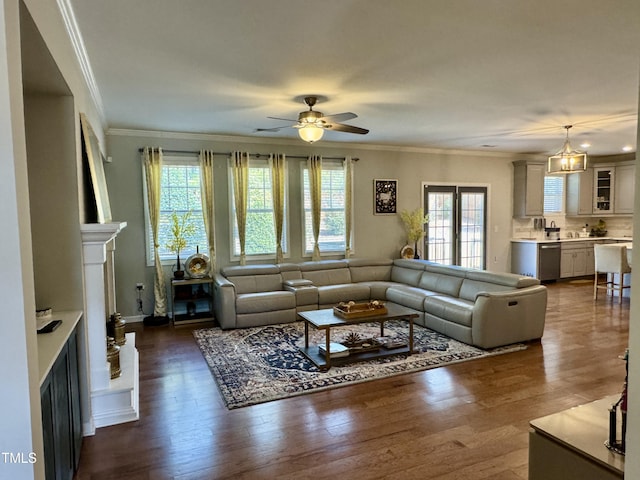 living area with ceiling fan, dark wood-style flooring, a fireplace, baseboards, and ornamental molding