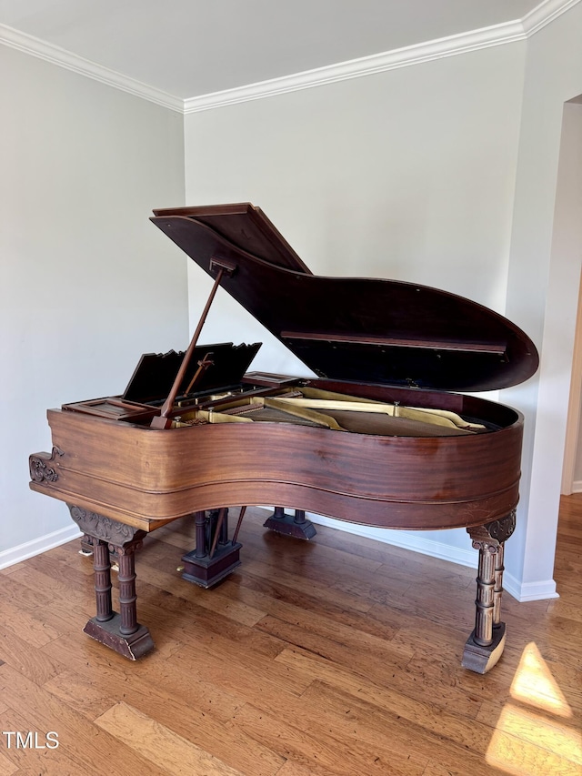 interior space with baseboards, crown molding, and wood finished floors