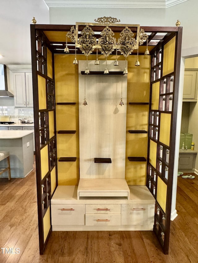 mudroom with ornamental molding and wood finished floors