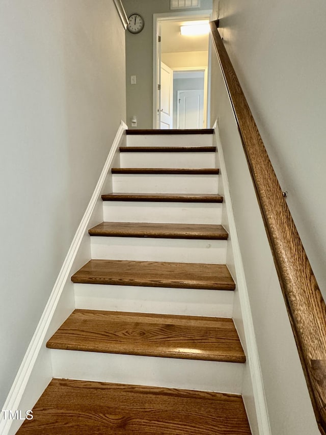 staircase featuring visible vents and baseboards