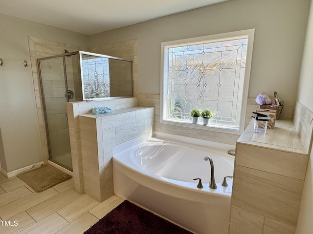 bathroom featuring a garden tub and a shower stall