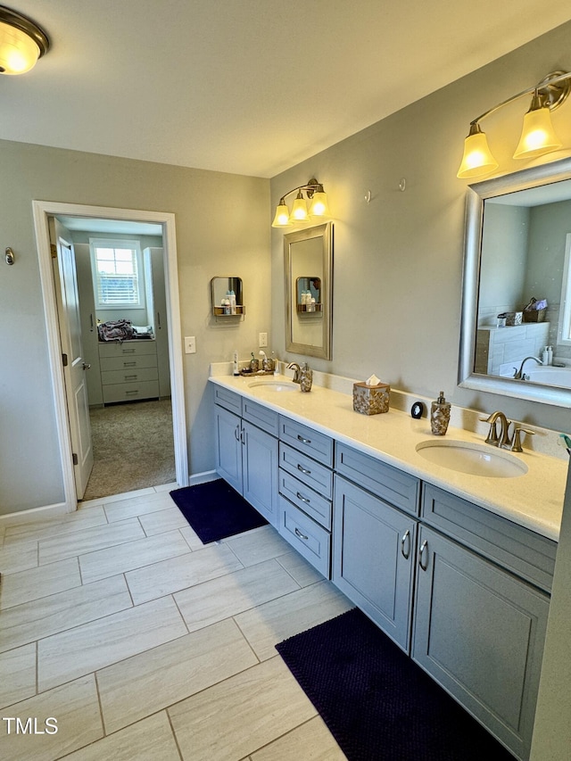 full bath with wood tiled floor, a sink, baseboards, and double vanity