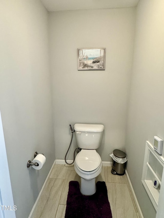 bathroom with toilet and baseboards