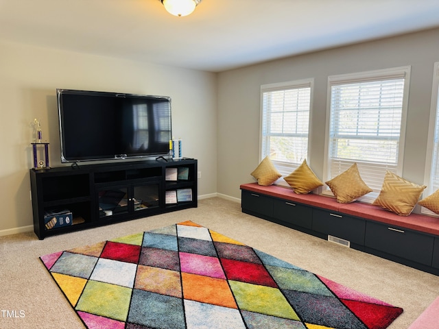 living area featuring carpet flooring, visible vents, and baseboards