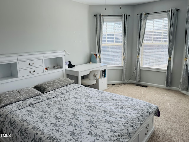 bedroom featuring carpet, multiple windows, visible vents, and baseboards