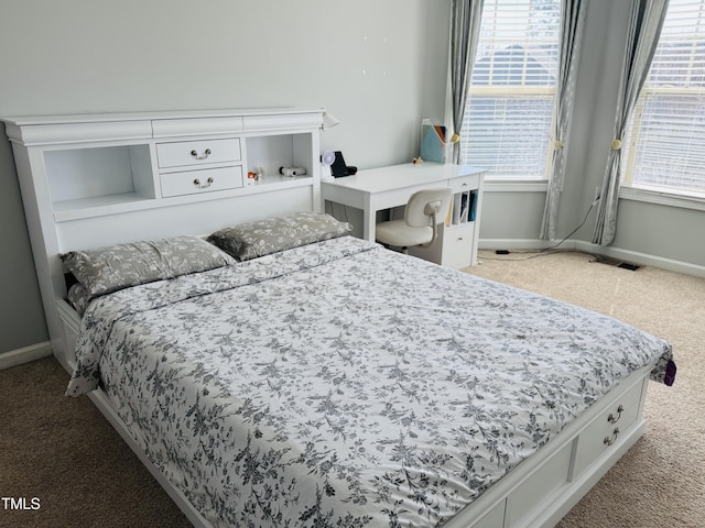 bedroom featuring multiple windows, baseboards, and carpet flooring