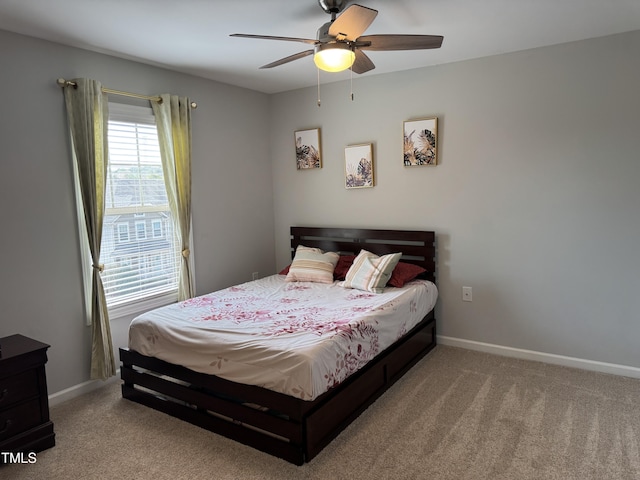 bedroom with a ceiling fan, baseboards, and carpet flooring