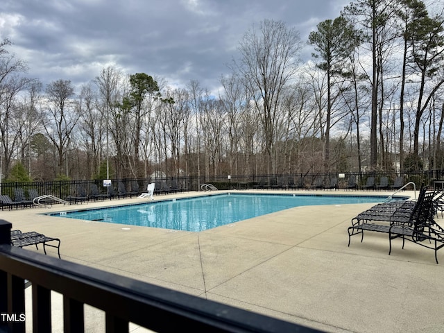 community pool featuring a patio and fence