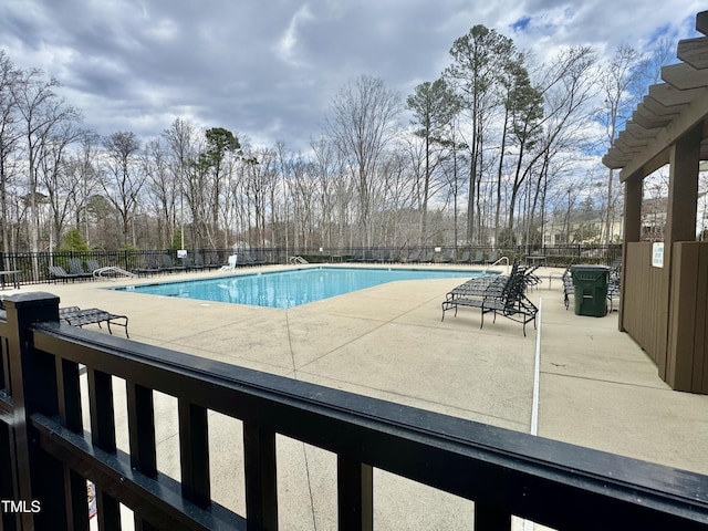 community pool featuring a patio and fence