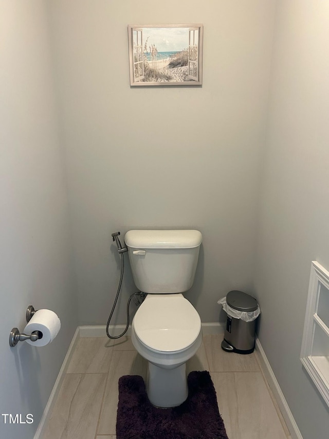 bathroom with toilet and baseboards