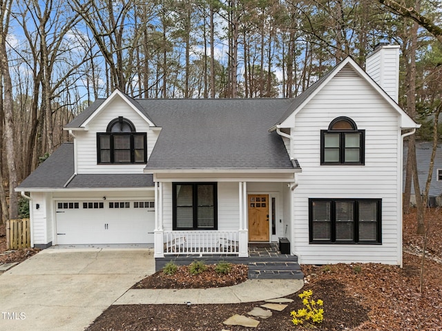 view of front of property featuring concrete driveway, roof with shingles, covered porch, a chimney, and a garage