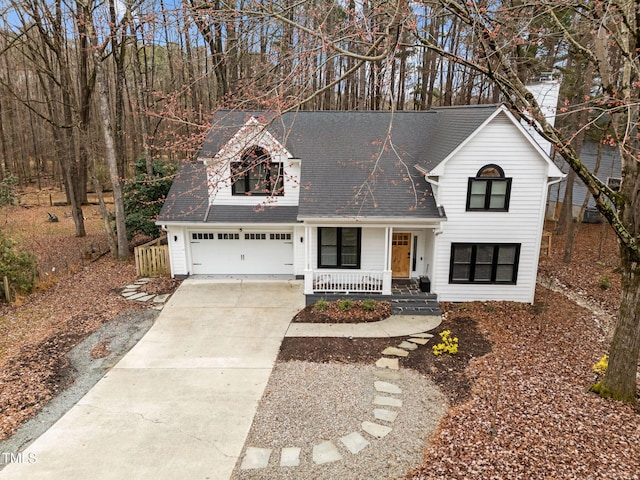 view of front of property featuring covered porch, concrete driveway, an attached garage, and a shingled roof