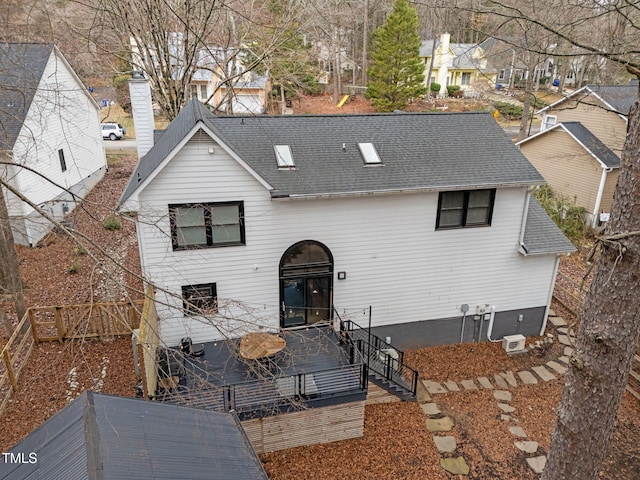 view of front facade with fence, a chimney, and a shingled roof