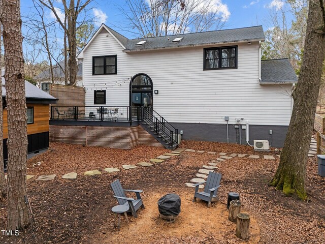 view of front facade featuring a shingled roof and a deck