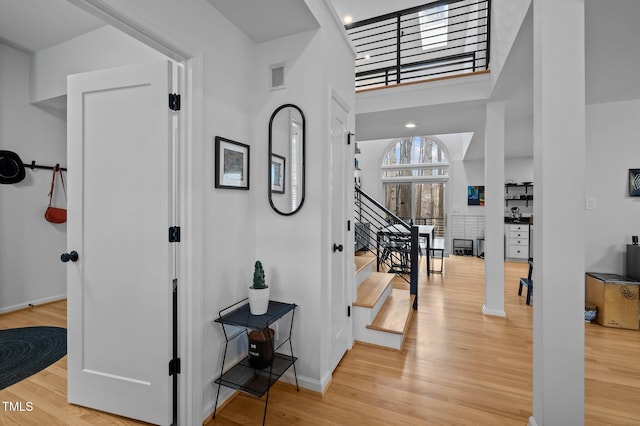 interior space with visible vents, baseboards, wood finished floors, and stairway