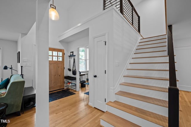 stairs with a high ceiling and wood finished floors