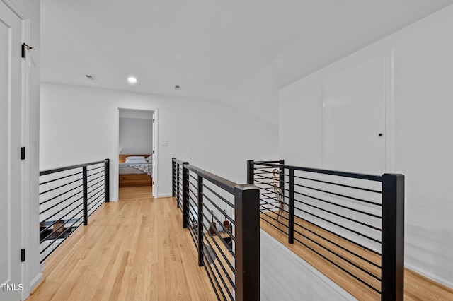 corridor with visible vents, baseboards, recessed lighting, an upstairs landing, and light wood-type flooring