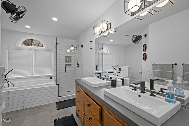 bathroom featuring double vanity, plenty of natural light, a stall shower, and a sink