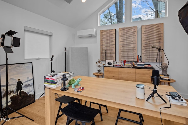 office space with high vaulted ceiling, light wood finished floors, and a wall mounted AC