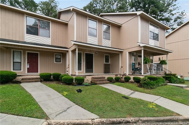 townhome / multi-family property featuring a porch and a front lawn