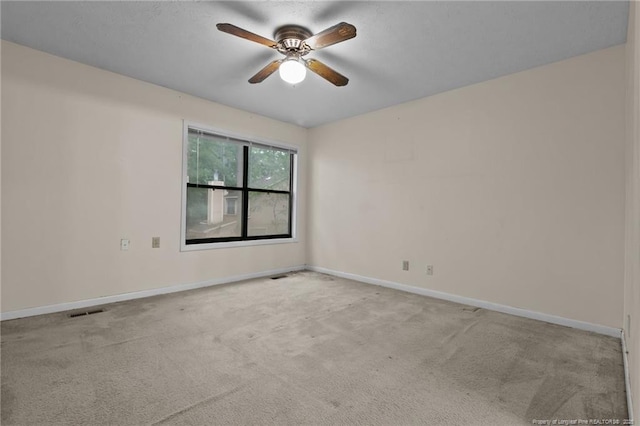 unfurnished room featuring a ceiling fan, carpet flooring, visible vents, and baseboards