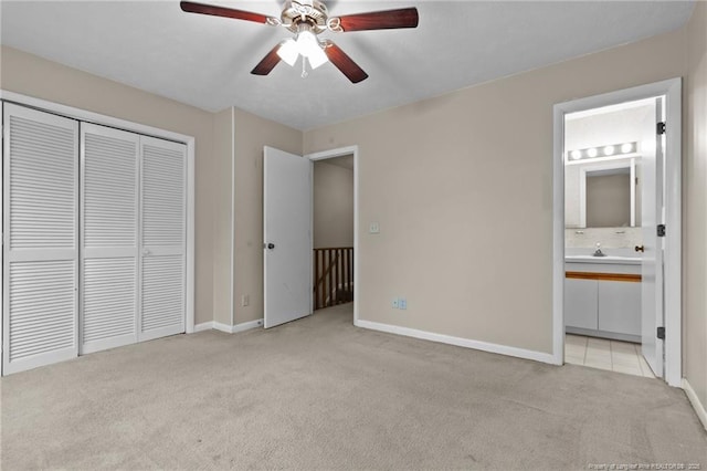 unfurnished bedroom with light carpet, ensuite bath, baseboards, and a closet