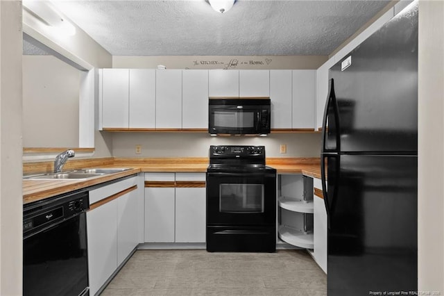 kitchen with black appliances, white cabinetry, and a sink