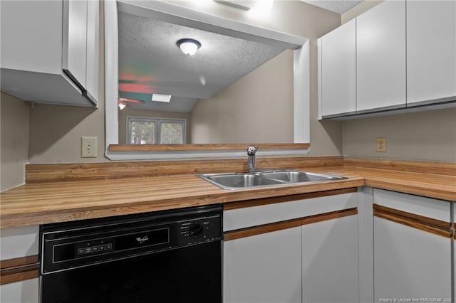 kitchen with butcher block counters, white cabinetry, dishwasher, and a sink