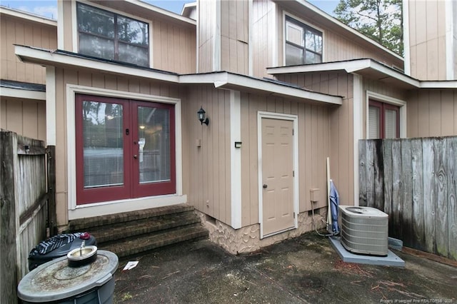 property entrance with french doors, fence, and central air condition unit