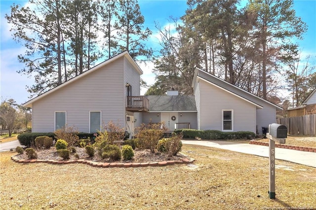 view of side of home featuring fence and a balcony