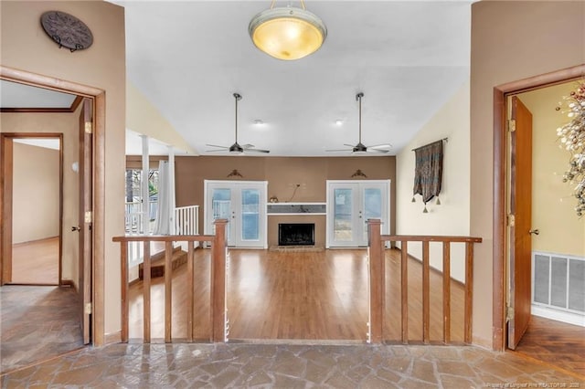 unfurnished living room featuring lofted ceiling, a fireplace, visible vents, and wood finished floors