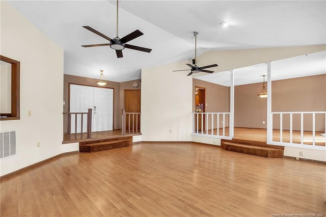 unfurnished living room with visible vents, vaulted ceiling, light wood-style flooring, and baseboards