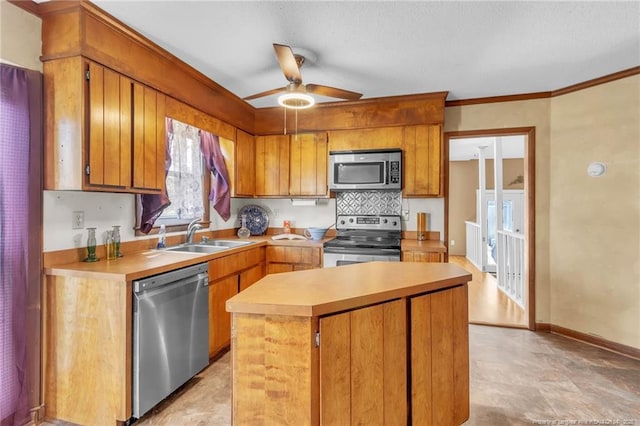 kitchen featuring light countertops, appliances with stainless steel finishes, a kitchen island, and a sink