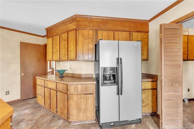 kitchen featuring brown cabinetry, light countertops, crown molding, and stainless steel fridge with ice dispenser