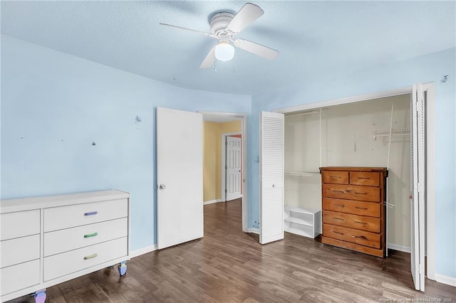 unfurnished bedroom featuring a ceiling fan, a closet, baseboards, and wood finished floors