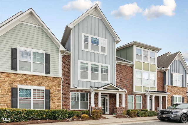 townhome / multi-family property featuring brick siding and board and batten siding